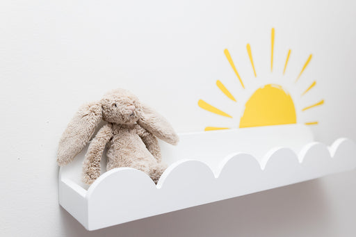 Plush bunny toy on a white shelf with a yellow sun reusable decal sticker on a light gray background