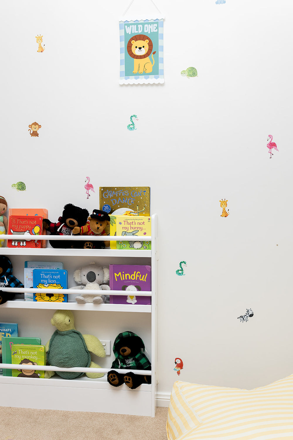 Children's room with shelves filled with books and toys, reusable wall decal stickers of animal decorations.