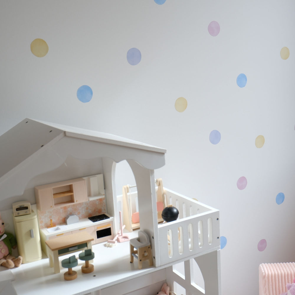 Children's playhouse with furniture against a wall with reusable colorful polka dot decal stickers